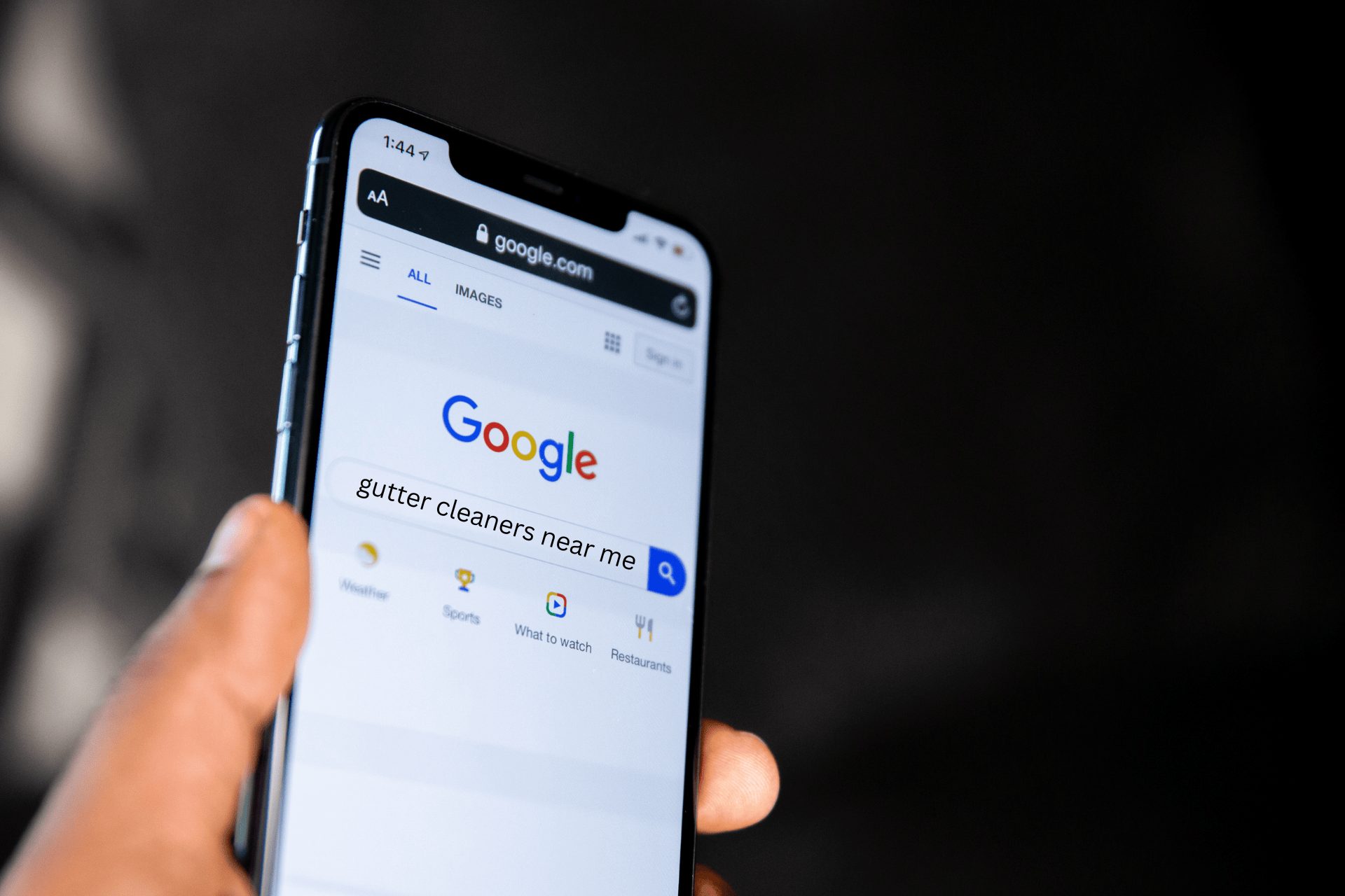 A man holding his iPhone after searching on Google for gutter cleaners near me